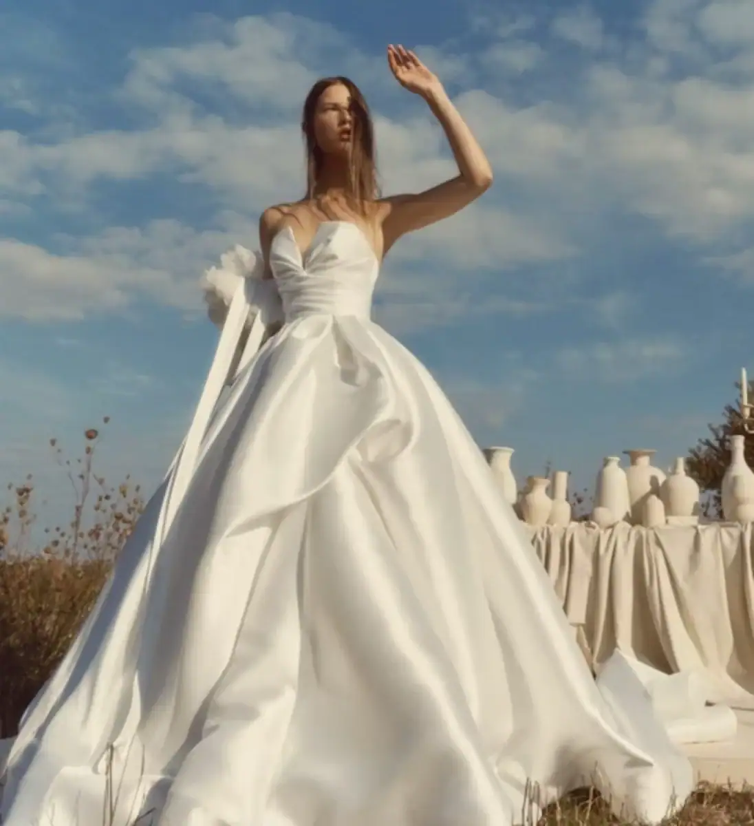 ball gown wedding dress with asymmetrical layered skirt and strapless v neckline