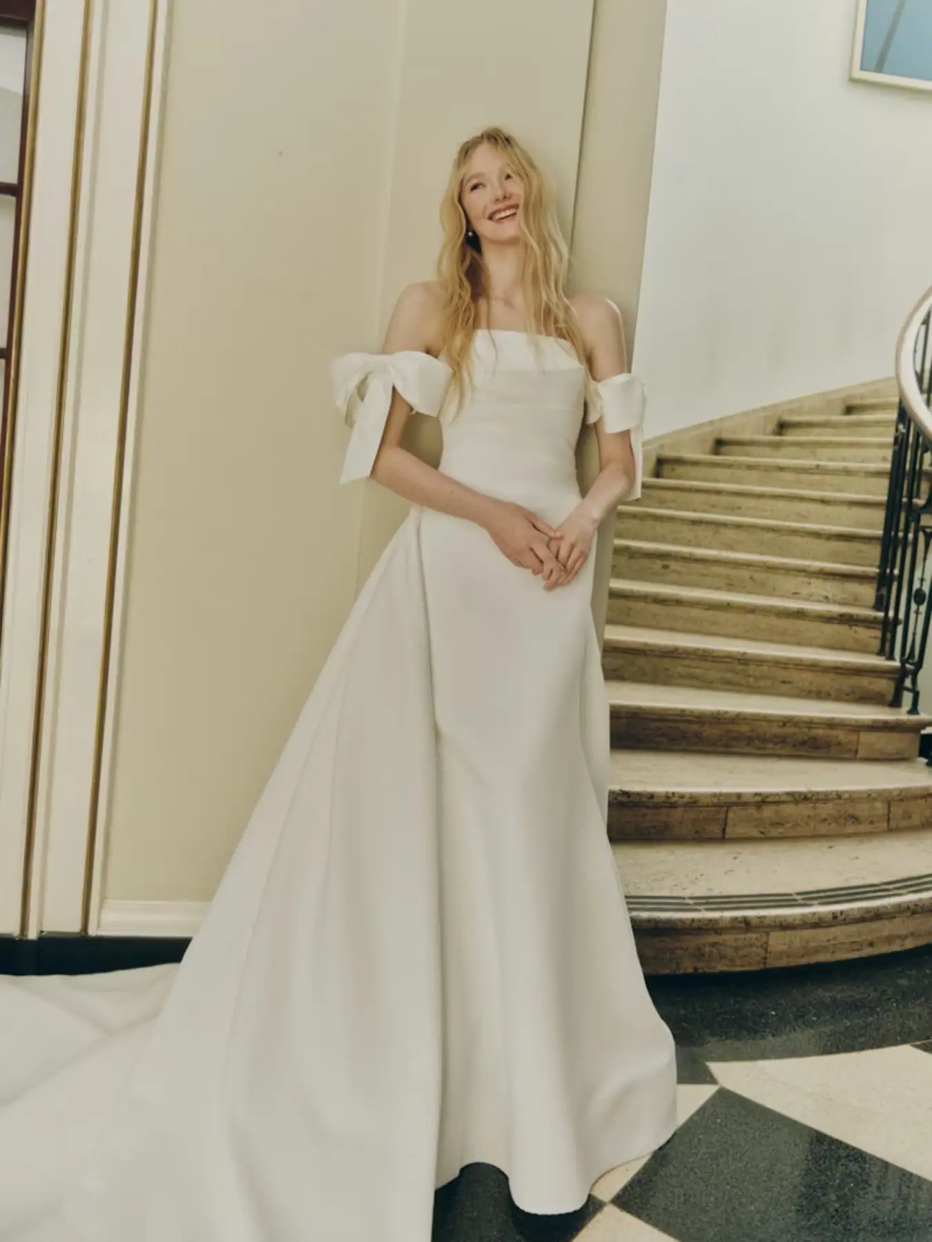 Fit and flare wedding dress with off the shoulder bows and an overskirt