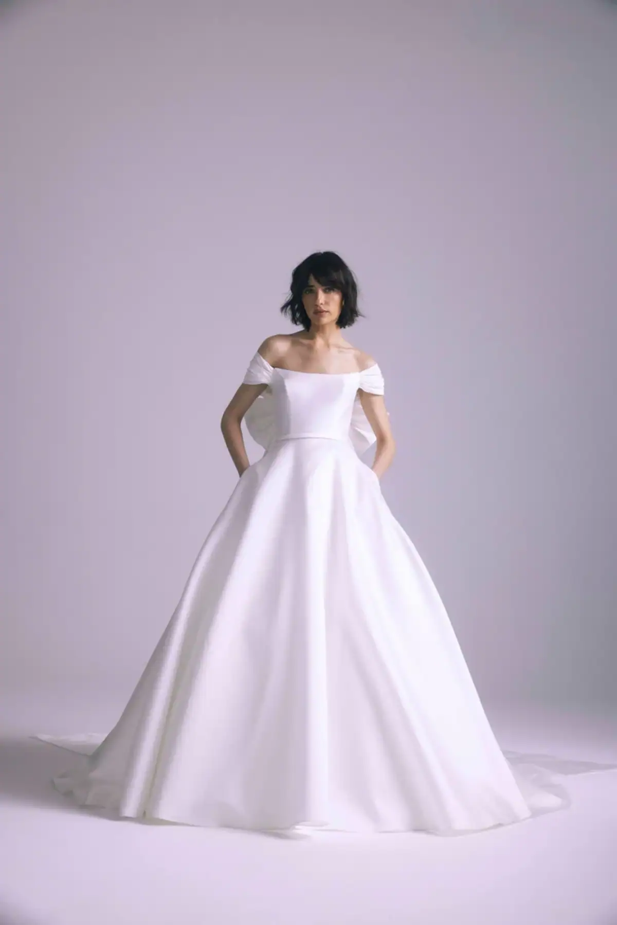 full front of amsale antonia ivory ball gown wedding dress with an off the shoulder neckline and bow at the back