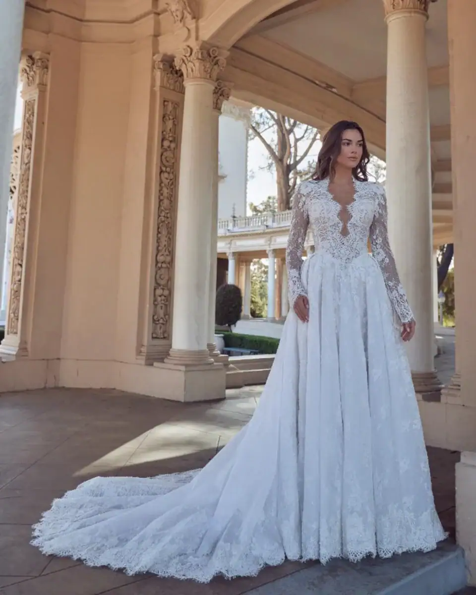 full front of calla blanche louisa lace ball gown with a basque waist, scalloped v neckline, and long sleeves