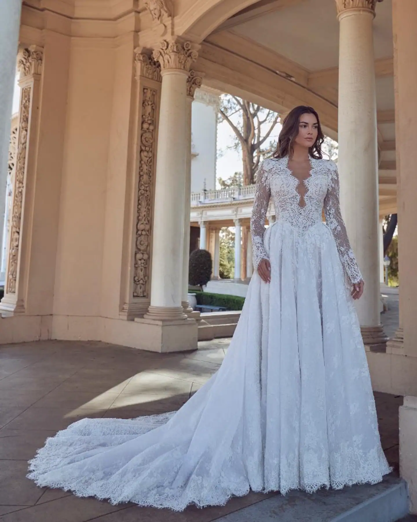 full front of calla blanche louisa lace ball gown with a basque waist, scalloped v neckline, and long sleeves