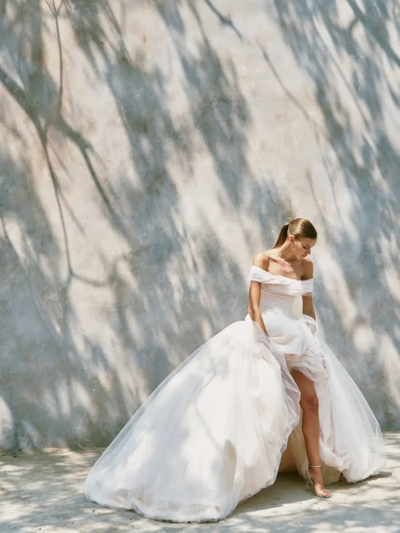 full front of nicole + felicia nf162 ivory tulle ball gown wedding dress with an off the shoulder neckline
