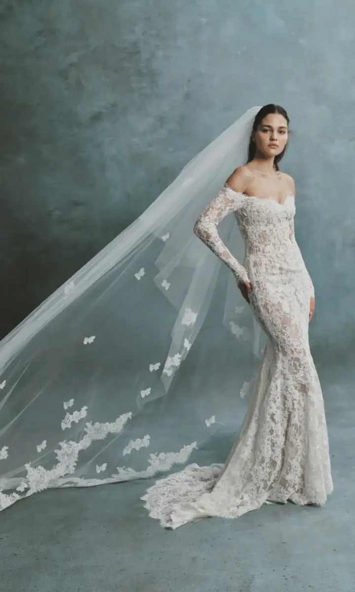 full front of senstudio se118 ivory and nude lace fitted wedding dress with an off the shoulder long sleeve neckline