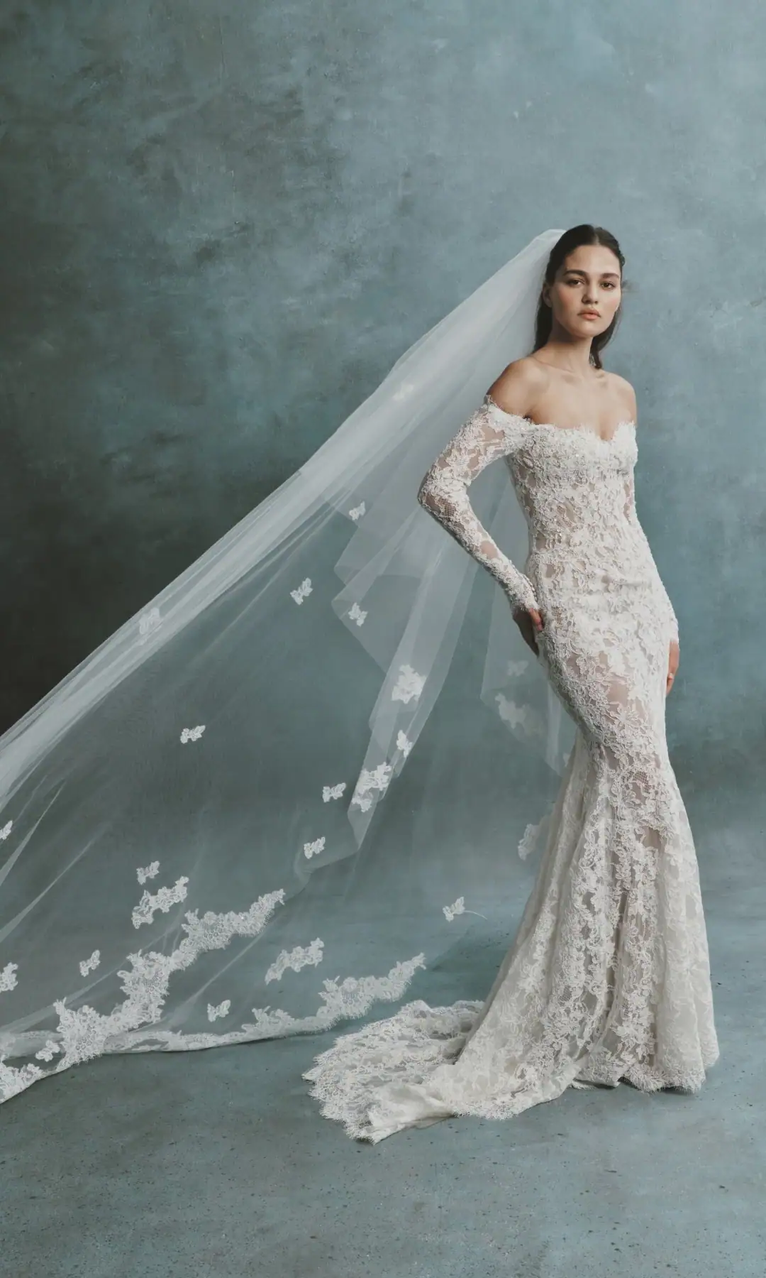 full front of senstudio se118 ivory and nude lace fitted wedding dress with an off the shoulder long sleeve neckline