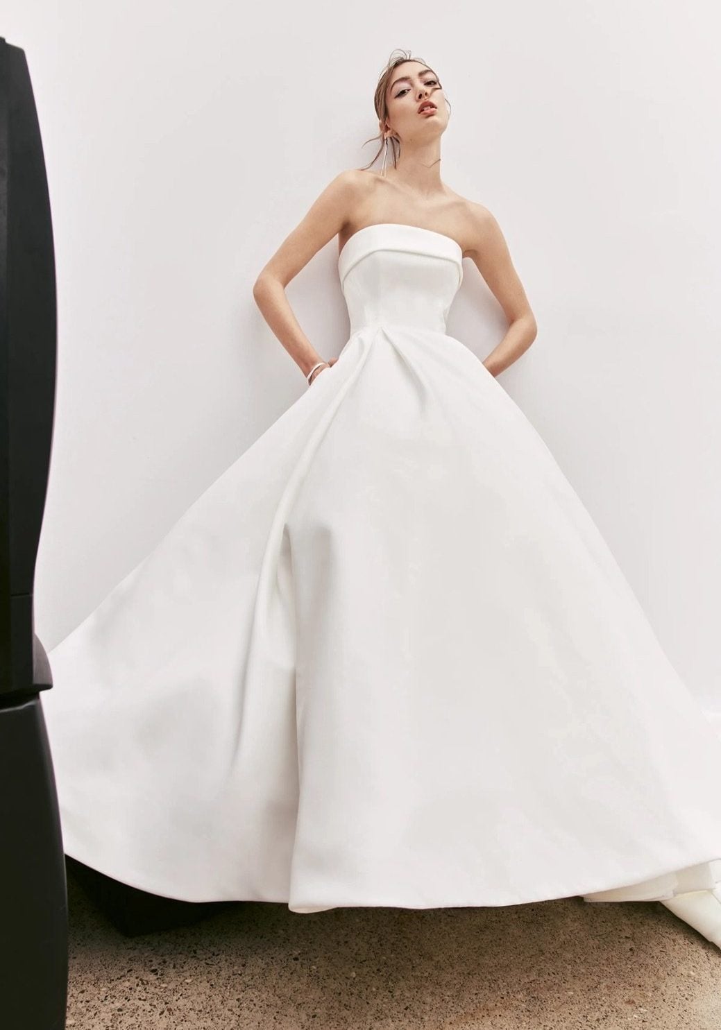Alyne Maci banded strapless ball gown with back cut-out, bow detail and buttons to hem